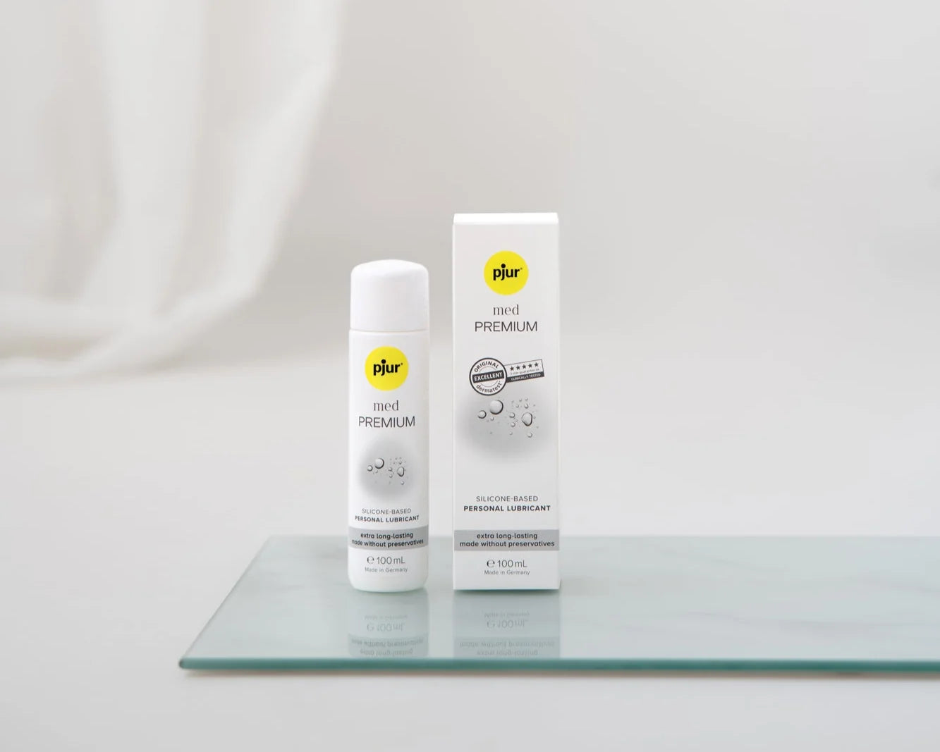 Pjur med Premium Glide 100ml – silikonebaseret glidecreme uden konserveringsmidler, velegnet til sensitiv hud og langvarig nydelse. Diskret og elegant flaske med matchende æske på glasplade.