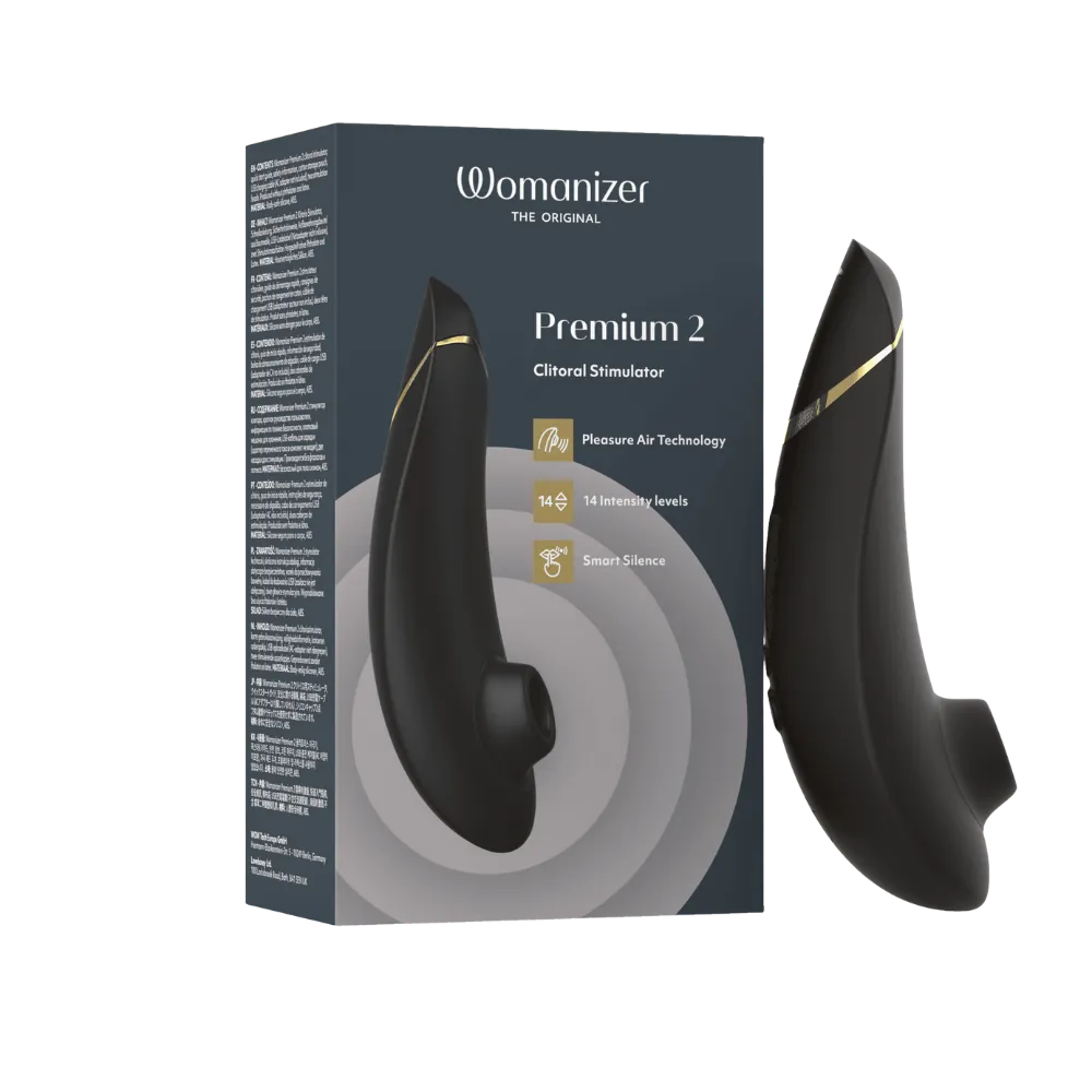 Womanizer Premium 2 clitoral stimulator i sort med gyldne detaljer ved siden af sin originale æske. Eksklusivt intimprodukt med Pleasure Air Technology og 14 niveauer af intens stimulering.