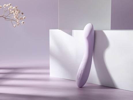 Lavendelfarvet G-punktsvibrator i roligt studie-setup med bløde skygger. Elegant valg til kropslig nydelse og diskret selvforkælelse.