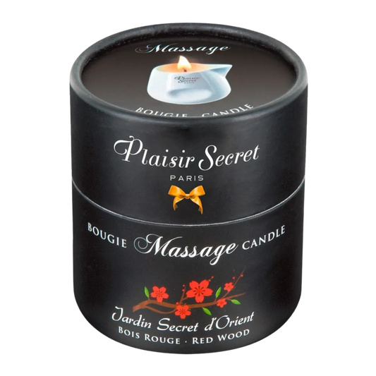 Sort æske med Plaisir Secret Massage Candle – Jardin Secret d’Orient, en sanselig massagelys med duft af rødtræ og orientalske noter. Elegant design med rød blomsterillustration og diskret luksus til intim velvære.