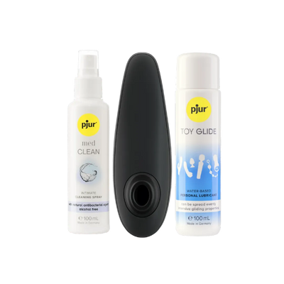 Womanizer Classic 2 lufttryksvibrator placeret mellem Pjur Toy Glide glidecreme og Pjur Med Clean rengøringsspray. Et komplet intimprodukt-sæt skabt til sanselig stimulering, silkeblød glideoplevelse og sikker rengøring i moderne erotisk wellness