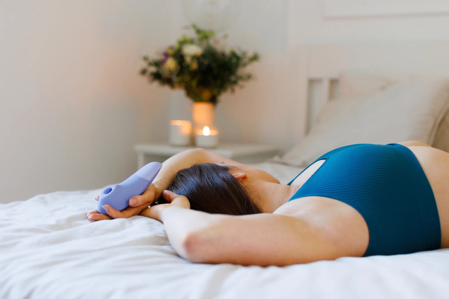 Womanizer Enhance vist i hånden med tydelige kontrolknapper til lufttryk og vibration. En intuitiv klitorisstimulator, der giver dig fuld kontrol over din oplevelse.