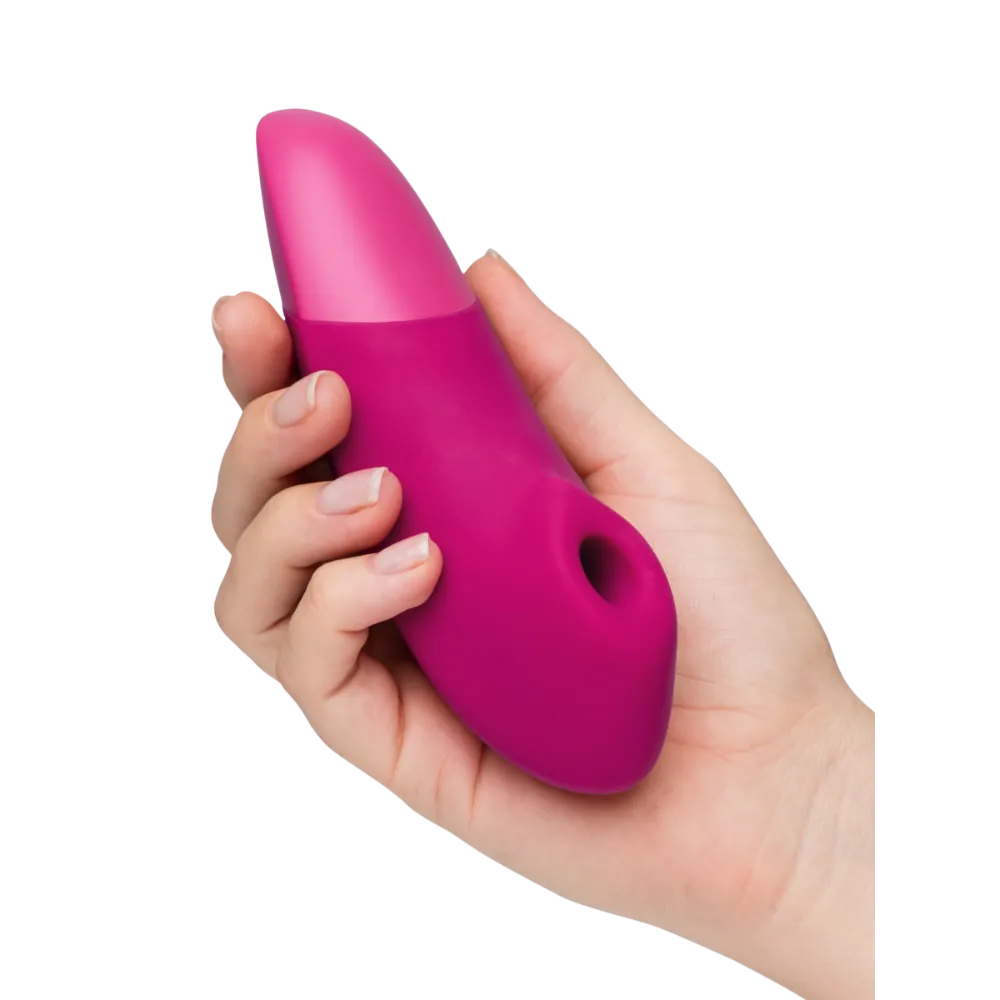 Womanizer Enhance vibrator i pink holdt i hånden, et eksklusivt sexlegetøj med Pleasure Air teknologi og vibrationsfunktion, skabt til sanselig nydelse, diskret stimulering og intim wellness i hverdagen.